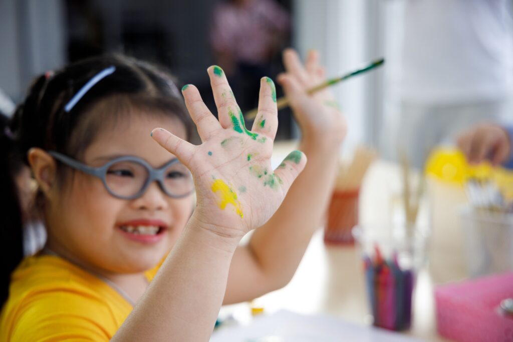 A Young Girl With Colorful Paint Smudges on Her Hands